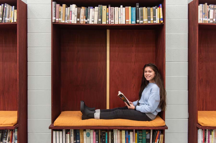 Bella reads in the Wheaton Academy library
