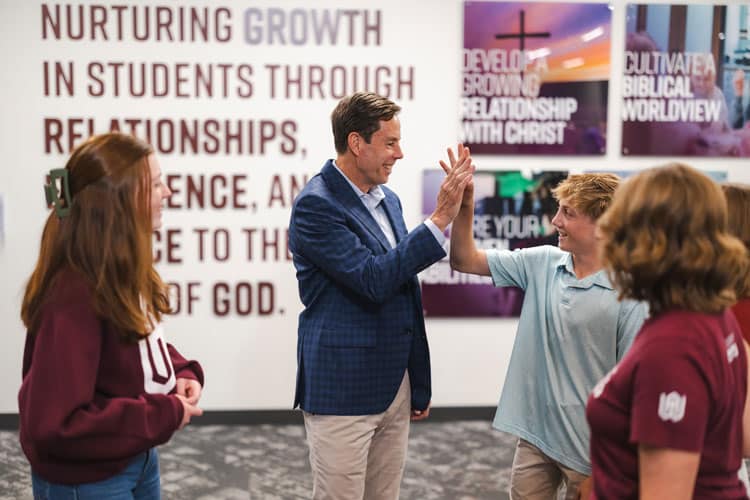 Mike greets students in the hallway.